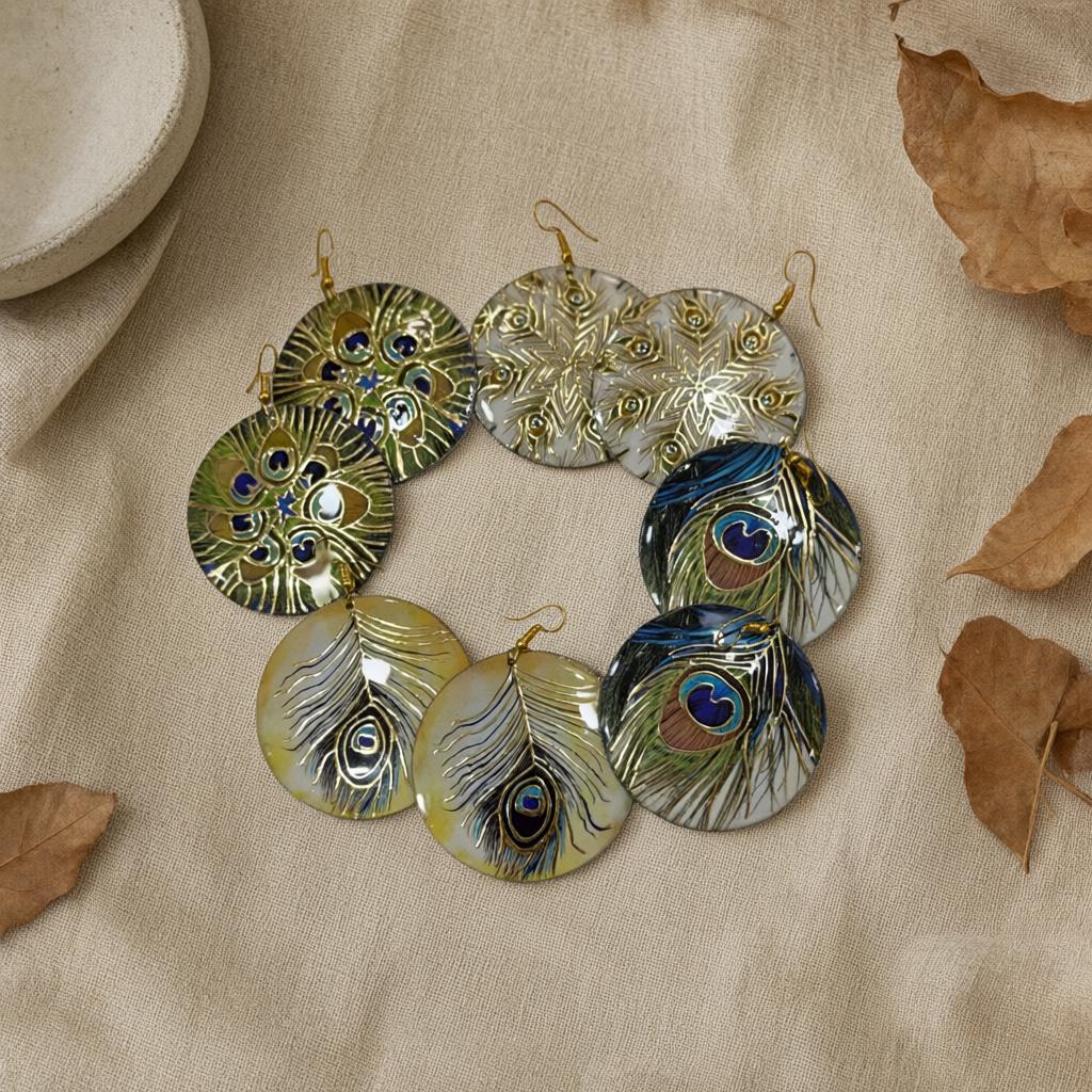 Pendientes Redondos de Concha con Grabado Pluma de Pavo Real y Detalles Dorados desde arriba para mujer Angara Moda