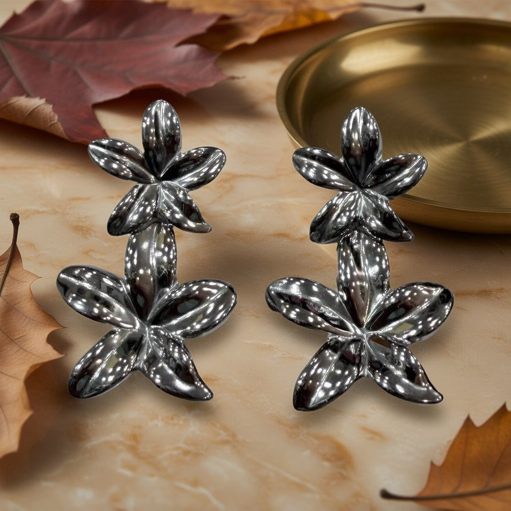 Pendientes Nenúfar Doble Flor Metal Acabado Espejo Oversize sobre una superficie para mujer Angara Moda