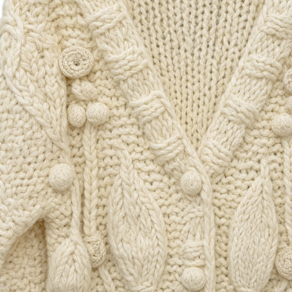 Detalle del tejido de Cardigan Florinda de punto trenzado con flores y botones joya para mujer Angara Moda