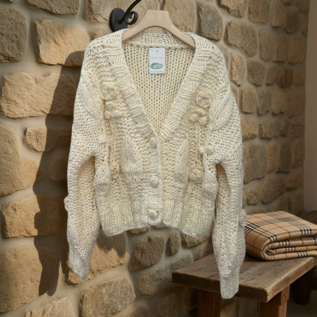 Cardigan Florinda de punto trenzado con flores y botones joya colgada en un ambiente para mujer Angara Moda