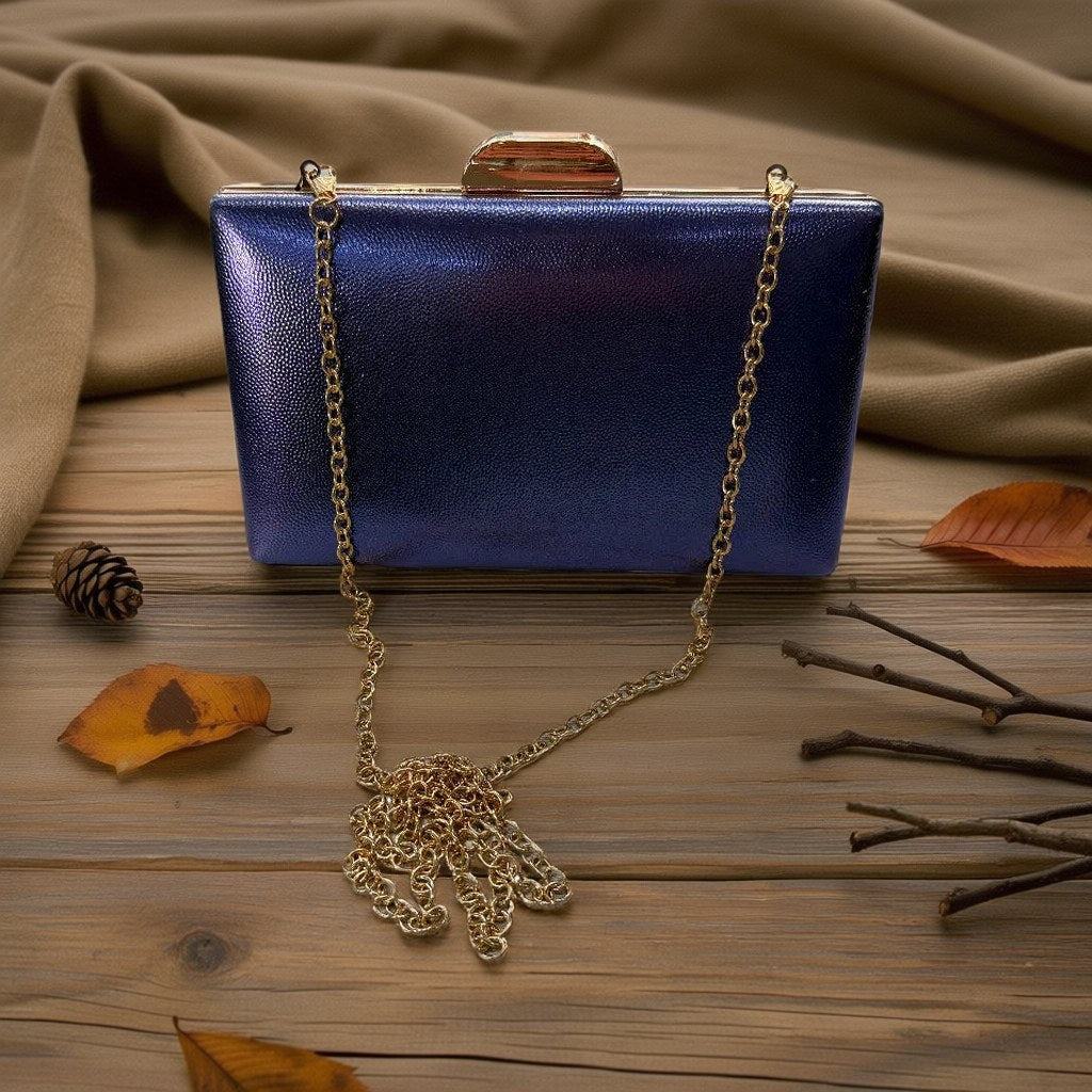 Bolso Luciano clutch de acabado pebble con cierre dorado y cadena desmontable sobre arena y lino con fondo natural para mujer Angara Moda