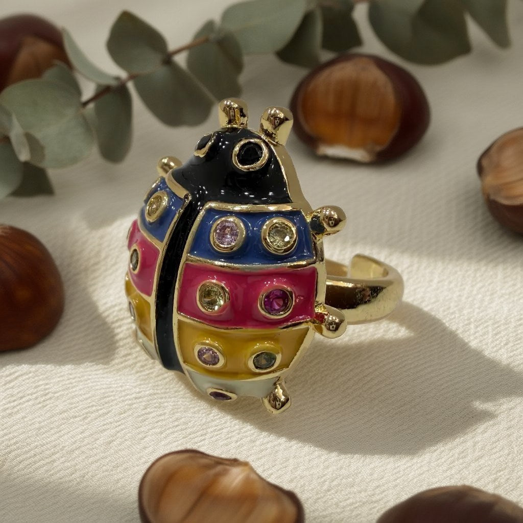 Anillo Carolina bañado en oro con mariquita esmaltada y cristales sobre una superficie para mujer Angara Moda