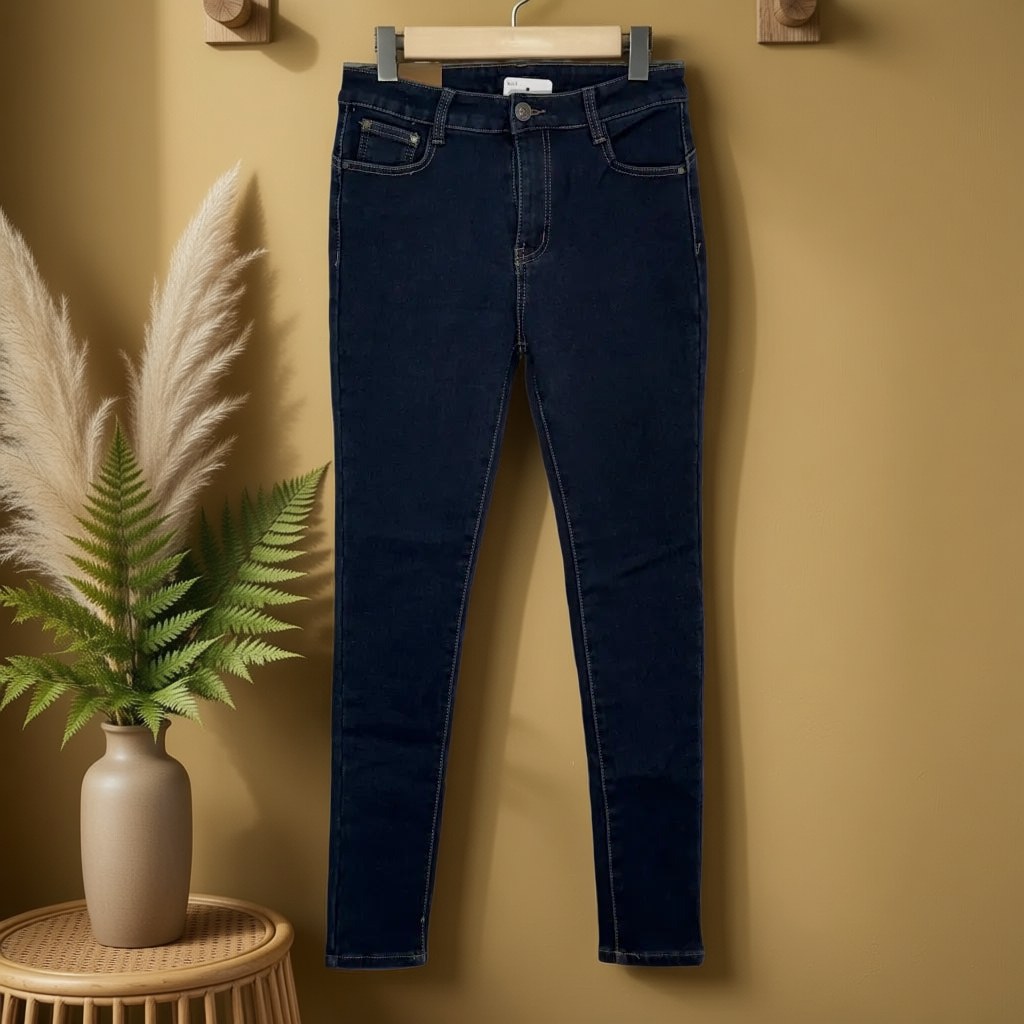 Pantalón vaquero pitillo de denim elástico con tiro alto y etiqueta de cuero Oeste colgada en un ambiente para mujer Angara Moda