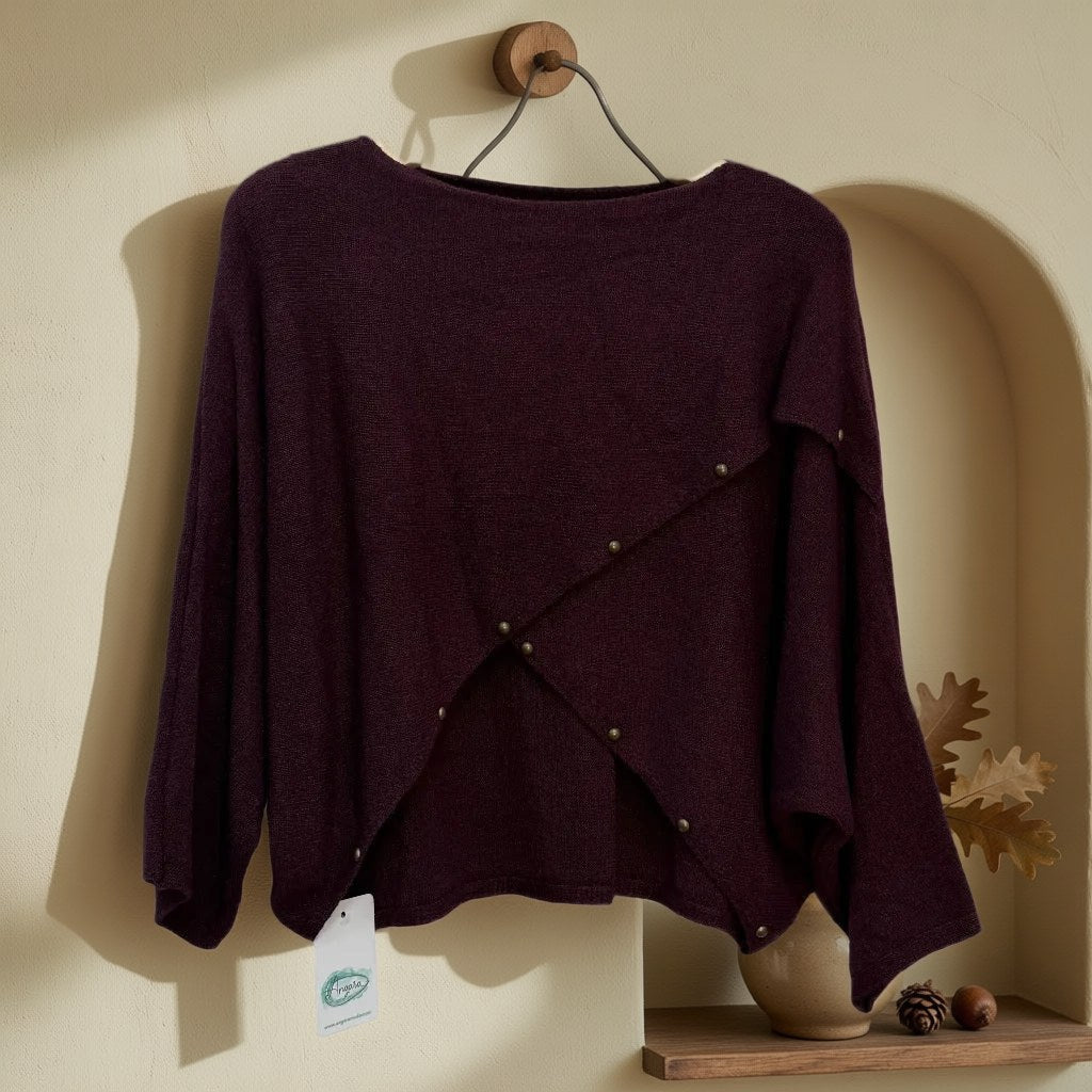 Jersey Rebeca de punto con diseño asimétrico colgada en un ambiente para mujer Angara Moda