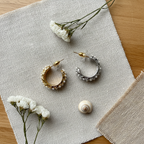 Flat lay pendientes Eloísa aro trenzado perlas complementos boho Angara Moda